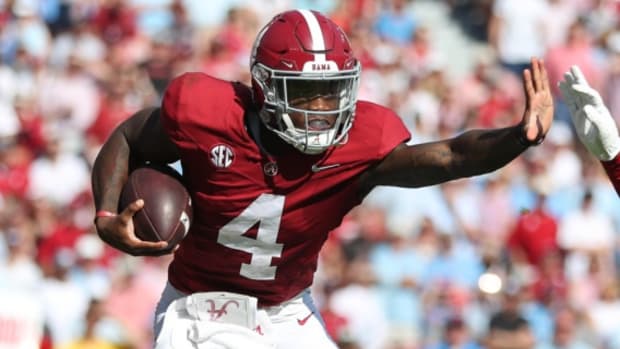 Alabama Crimson Tide quarterback Jalen Milroe on a rushing attempt during a college football game in the SEC.